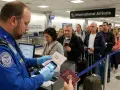 Kolejka do odprawy celnej na lotnisku. Agent TSA sprawdza dokumenty podróżnych.