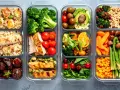 Planowanie zakupów: posiłki w pojemnikach: kurczak, ryż, brokuły, pomidorki, awokado, marchewka, fasolka szparagowa, kukurydza, orzechy, owoce.