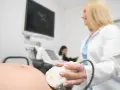 Lekarka wykonuje USG ciężarnej. To badanie pozwala sprawdzić, jak często można robić usg w ciąży, by monitorować rozwój dziecka.