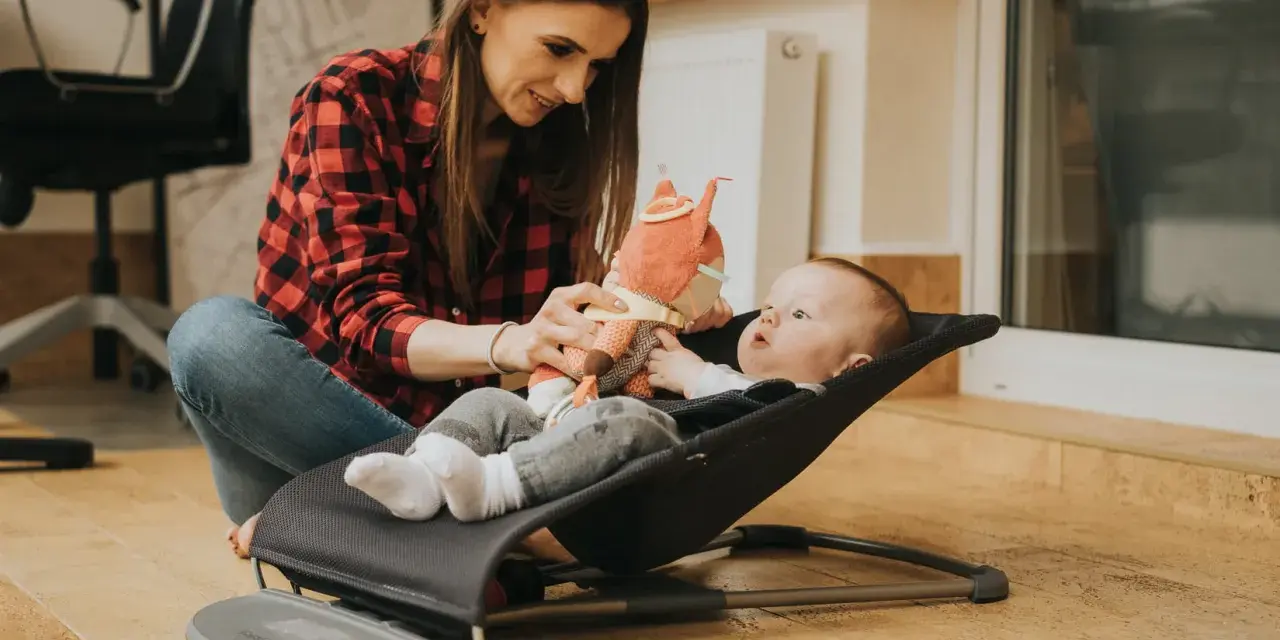 Mama bawi się z dzieckiem w bujaczku Babybjorn. Od kiedy maluch może z niego korzystać? Od pierwszych dni życia!