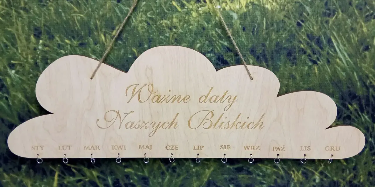 Drewniany kalendarz w kształcie chmurki z napisem "Ważne daty Naszych Bliskich". Poniżej miesiące od STY do GRU, z kółeczkami do zawieszania pamiątek. Idealny do zaznaczania każdego dnia urodzenia.