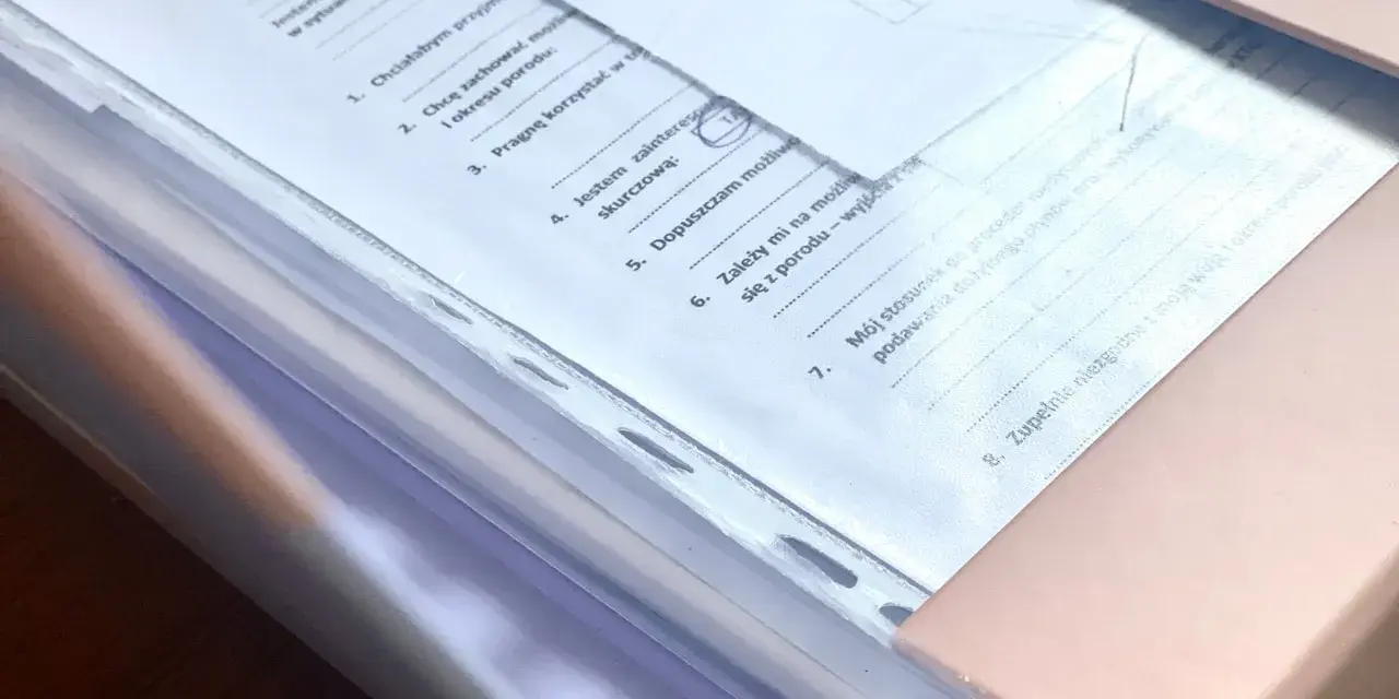Teczka ciążowa z dokumentami. Zawiera zasady przechowywania, informacje o preferencjach dotyczących porodu i stosunku do procedur medycznych.