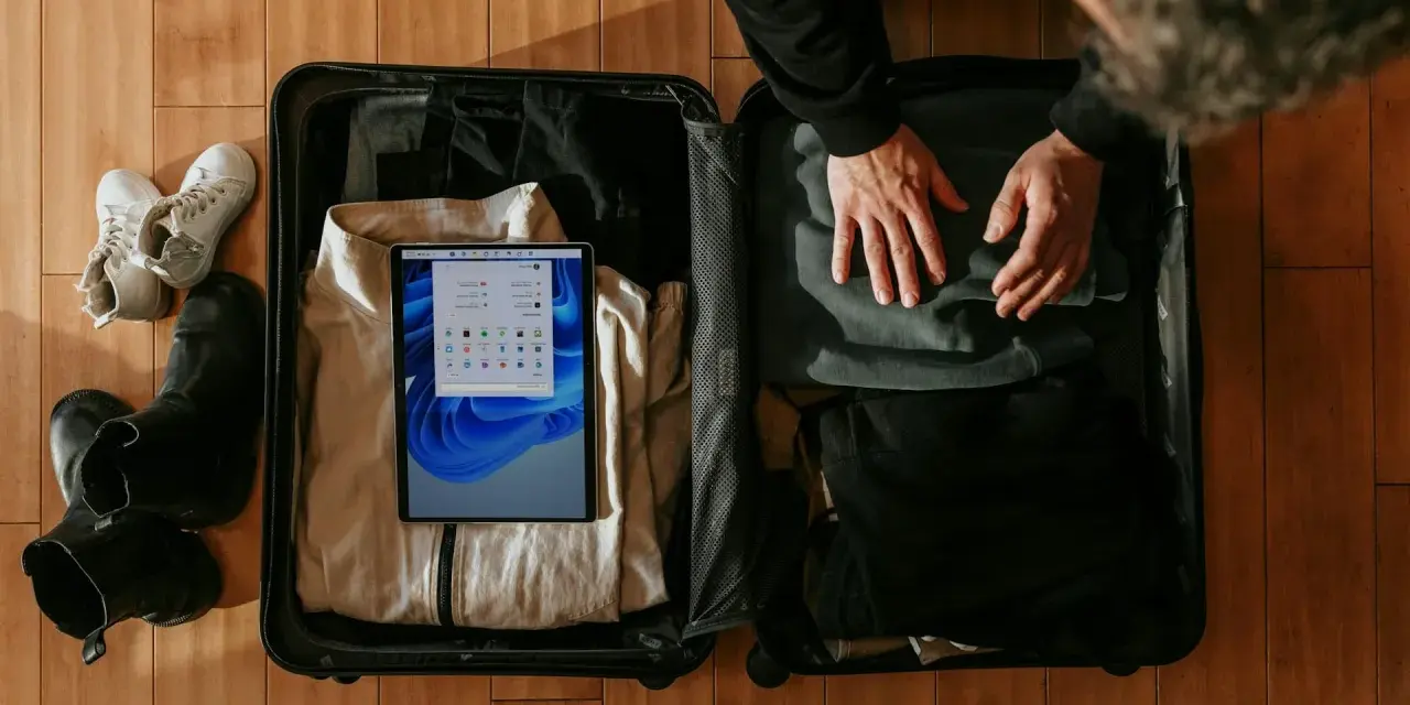 Pakowanie bagażu osobistego Wizzair: ubrania, buty i tablet z systemem Windows.
