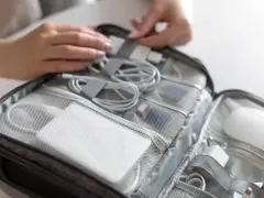Organizacja kabli i akcesoriów do laptopa w torbie podróżnej, idealna na lot samolotem.