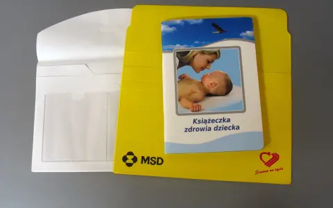 Żółta teczka na dokumenty dziecka z książeczką zdrowia.