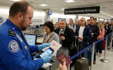 Kolejka do odprawy celnej na lotnisku. Agent TSA sprawdza dokumenty podróżnych.