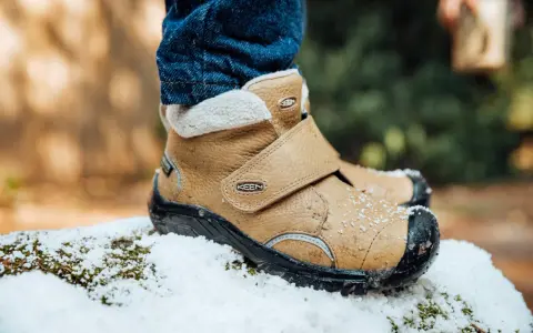 Pierwsze buty zimowe dla dziecka, brązowe, ocieplane, gotowe na śnieżne przygody.