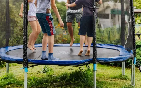 Dzieci skaczą na trampolinie. Od jakiego wieku można zacząć zabawę? Odpowiedź znajdziesz w instrukcji, ale radość jest uniwersalna!