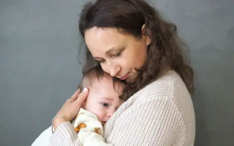 Matka tuli dziecko, które przeżywa lęk separacyjny. Jej delikatny dotyk i bliskość uspokajają malucha.
