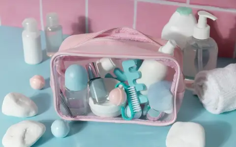 Różowa kosmetyczka z akcesoriami do makijażu i pielęgnacji, w tym perfumy w bagażu podręcznym.
