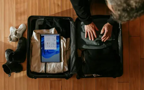 Pakowanie bagażu osobistego Wizzair: ubrania, buty i tablet z systemem Windows.