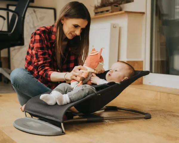 Mama bawi się z dzieckiem w bujaczku Babybjorn. Od kiedy maluch może z niego korzystać? Od pierwszych dni życia!