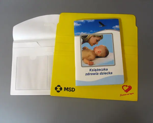 Żółta teczka na dokumenty dziecka z książeczką zdrowia.