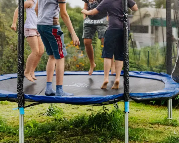 Dzieci skaczą na trampolinie. Od jakiego wieku można zacząć zabawę? Odpowiedź znajdziesz w instrukcji, ale radość jest uniwersalna!