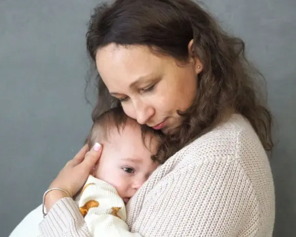 Matka tuli dziecko, które przeżywa lęk separacyjny. Jej delikatny dotyk i bliskość uspokajają malucha.