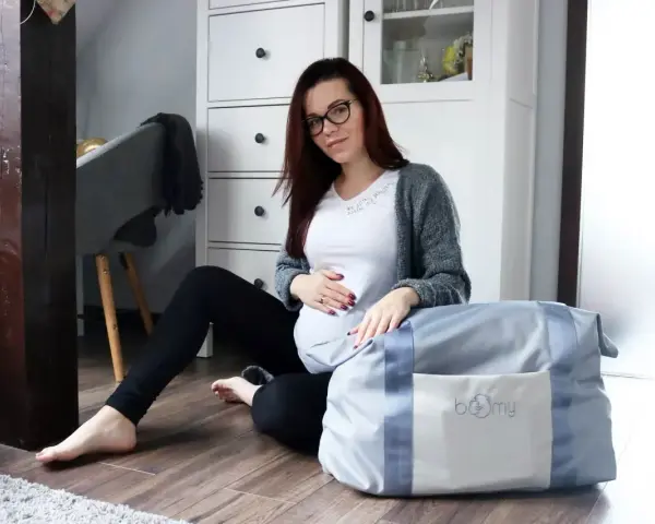 Gotowa na poród! Ciężarna kobieta z torbą na porodówkę.