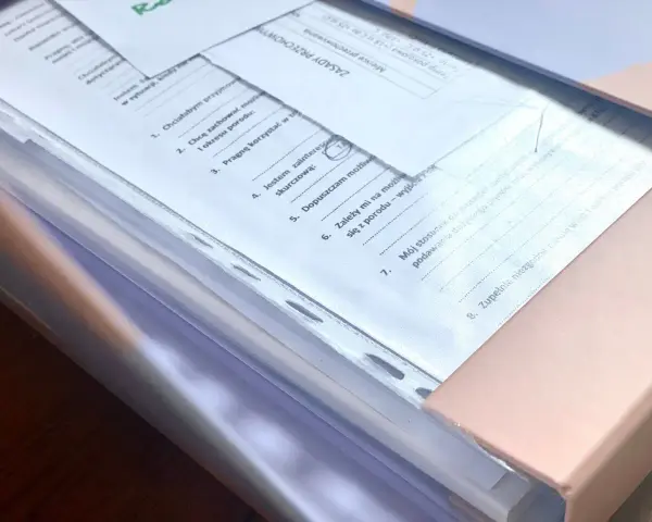 Teczka ciążowa z dokumentami. Zawiera zasady przechowywania, informacje o preferencjach dotyczących porodu i stosunku do procedur medycznych.