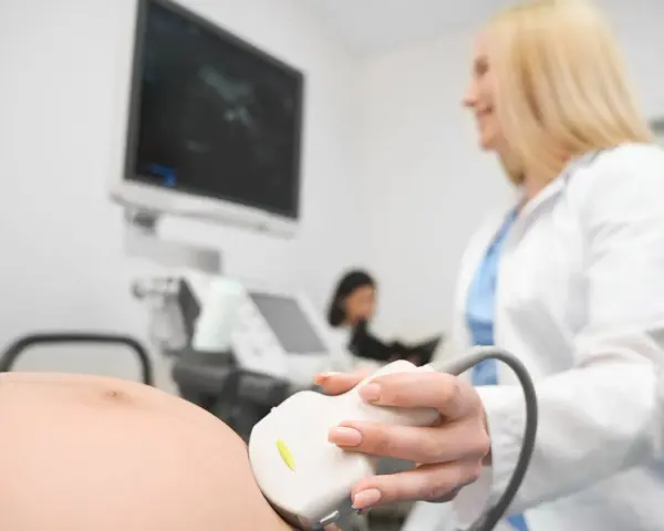 Lekarka wykonuje USG ciężarnej. To badanie pozwala sprawdzić, jak często można robić usg w ciąży, by monitorować rozwój dziecka.