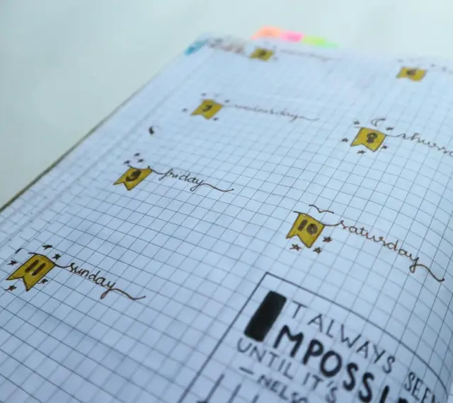 Urocze bullet journal inspiracje: dni tygodnia z flagami i cytat "Always seen impossible until it's done".