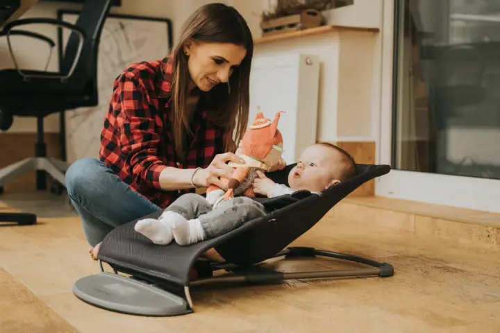Mama bawi się z dzieckiem w bujaczku Babybjorn. Od kiedy maluch może z niego korzystać? Od pierwszych dni życia!