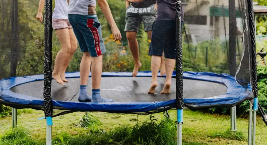 Dzieci skaczą na trampolinie. Od jakiego wieku można zacząć zabawę? Odpowiedź znajdziesz w instrukcji, ale radość jest uniwersalna!