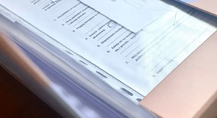 Teczka ciążowa z dokumentami. Zawiera zasady przechowywania, informacje o preferencjach dotyczących porodu i stosunku do procedur medycznych.