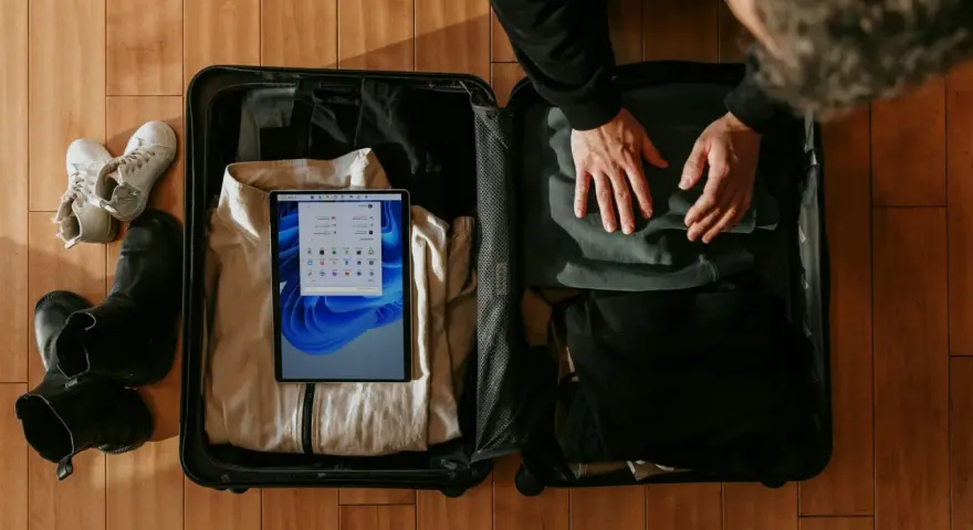 Pakowanie bagażu osobistego Wizzair: ubrania, buty i tablet z systemem Windows.