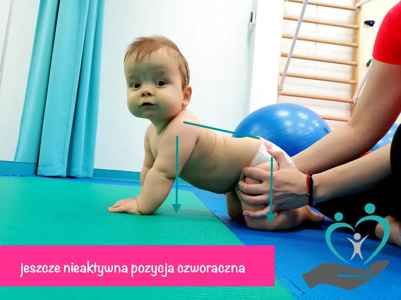 Dziecko w pozycji czworakowania, z rękami na macie. Fizjoterapeuta pomaga mu w osiągnięciu prawidłowej postawy.