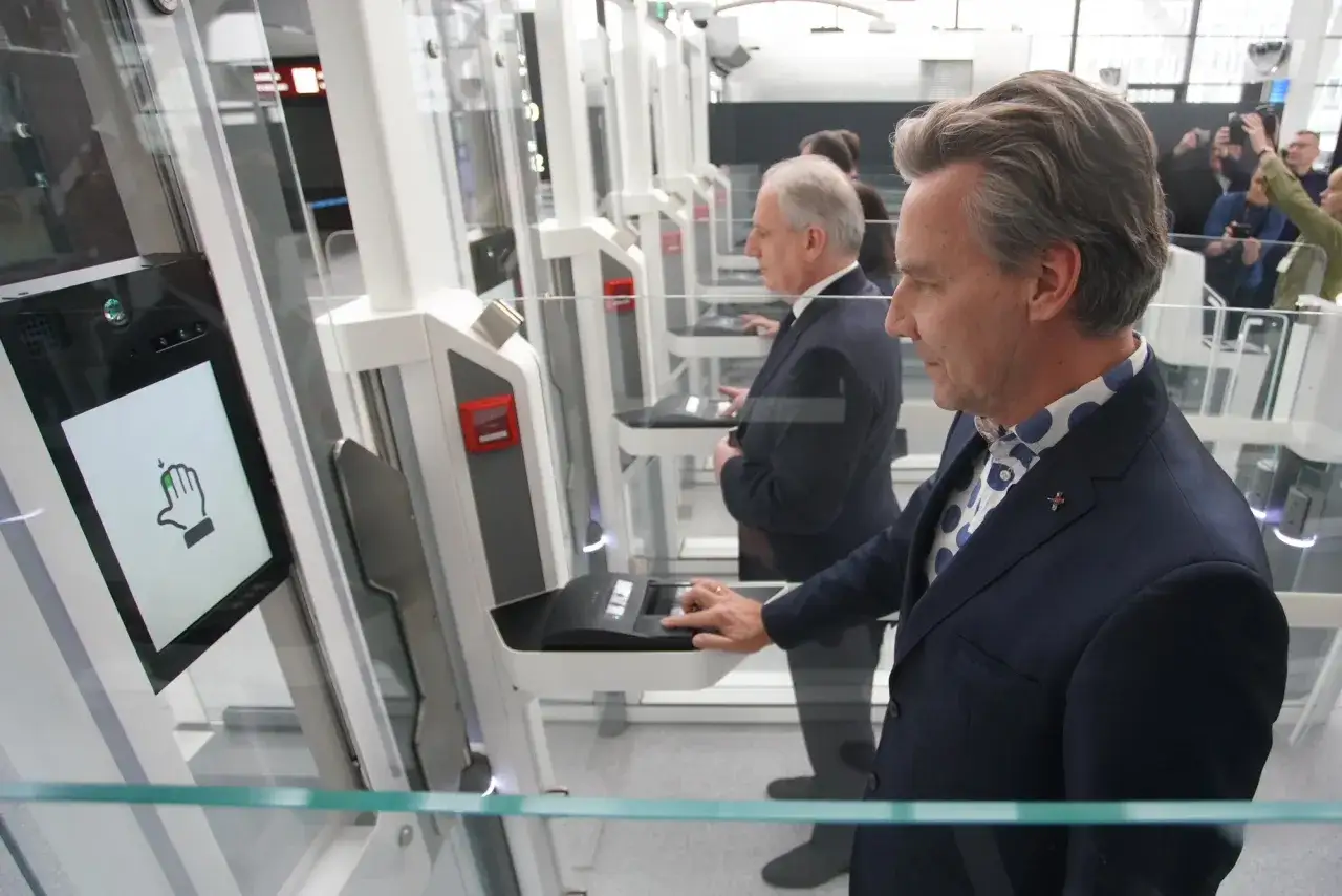 Mężczyzna w garniturze korzysta z automatycznej bramki podczas odprawy celnej na lotnisku.